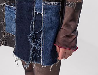 Фото джинсовой мини-юбки, сшитой из разных кусков ткани со рваными краями.